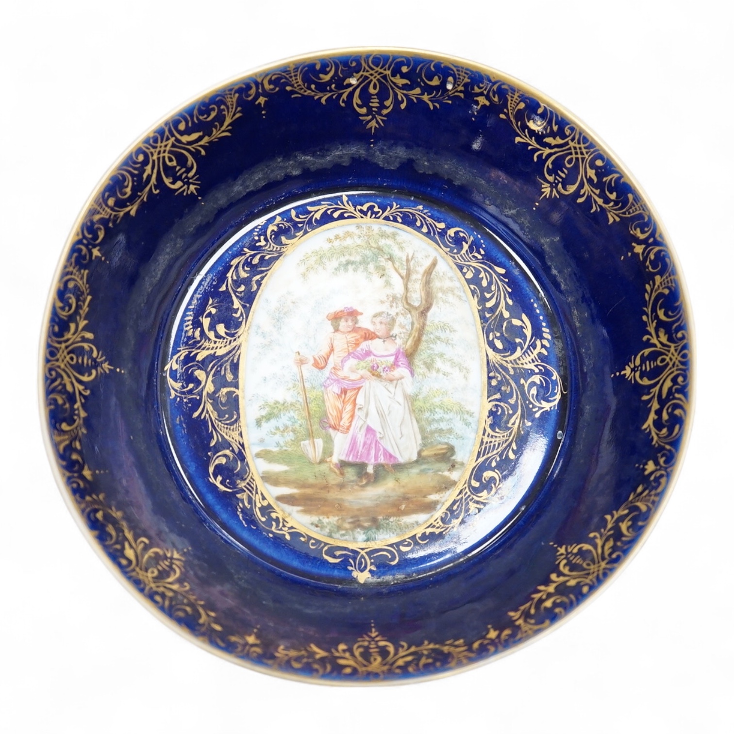 A 19th century Vienna saucer, hand painted with two figures beneath a tree, 15cm in diameter